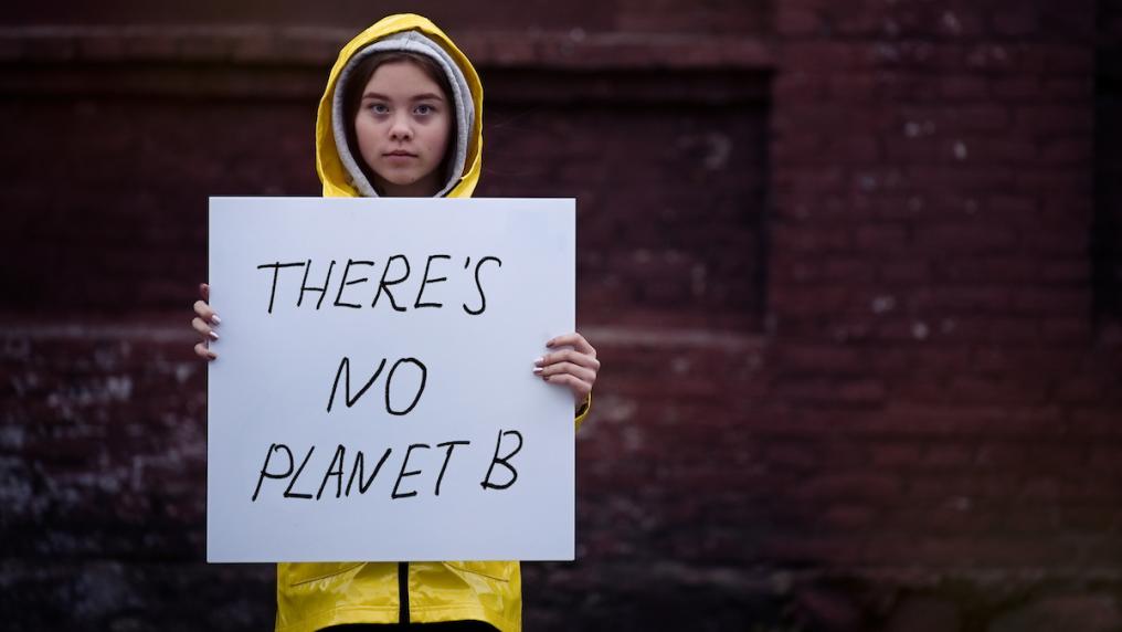 Young girl holding climate change protest sign