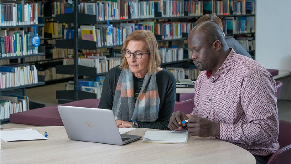 Two people in VU Library on laptop