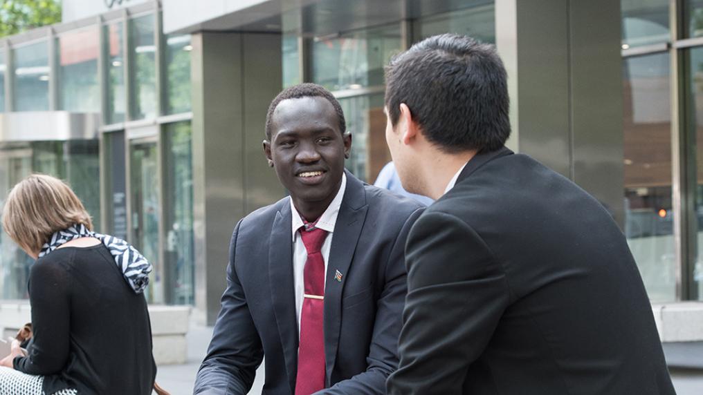 Business students Bol Matiang and Celil Said Kardaslar seated outside Country Court of Victoria