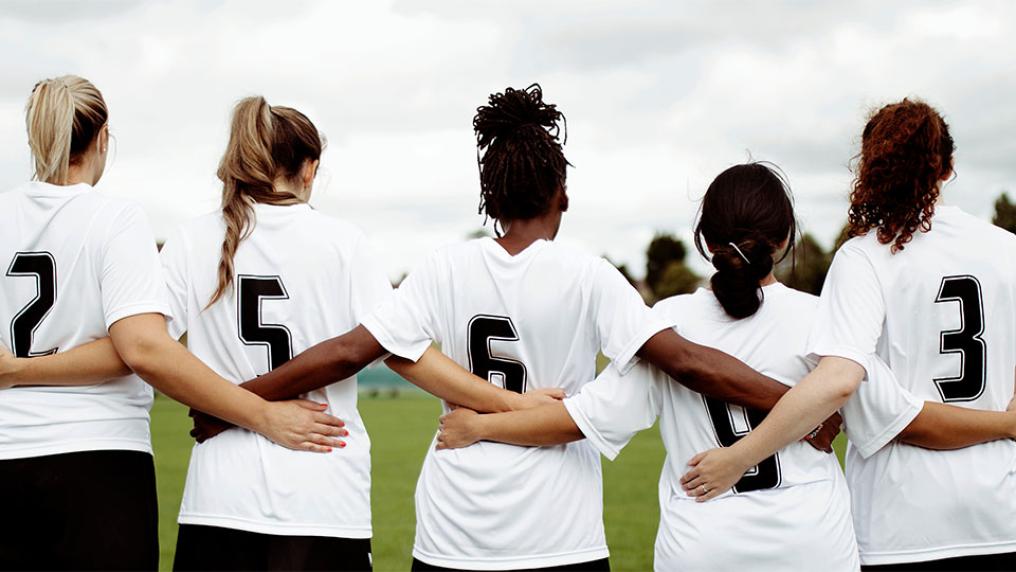 A sports team of females huddled together