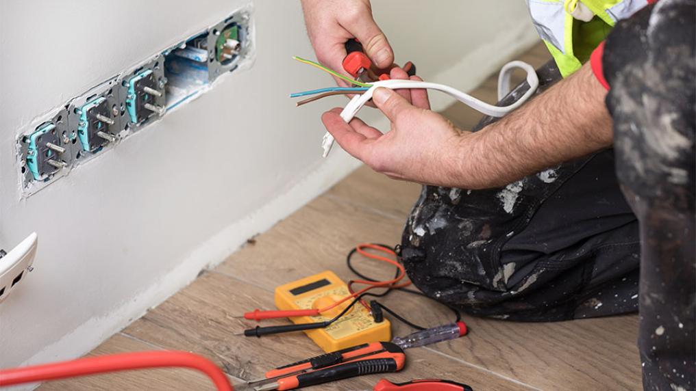 An electrician fixes a power point