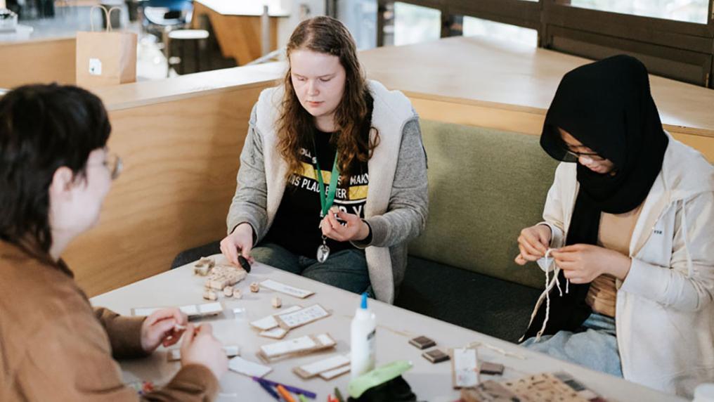 Volunteer students crafting at a table.