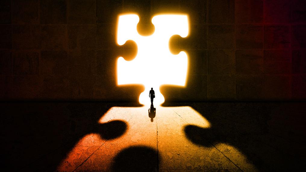 Person standing in the outline of a puzzle.