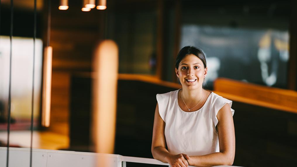 A young woman in professional dress in a modern office building