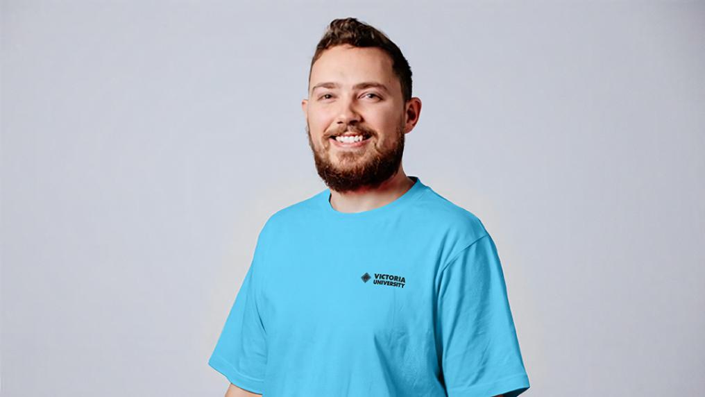 Male in blue t-shirt with Victoria University logo