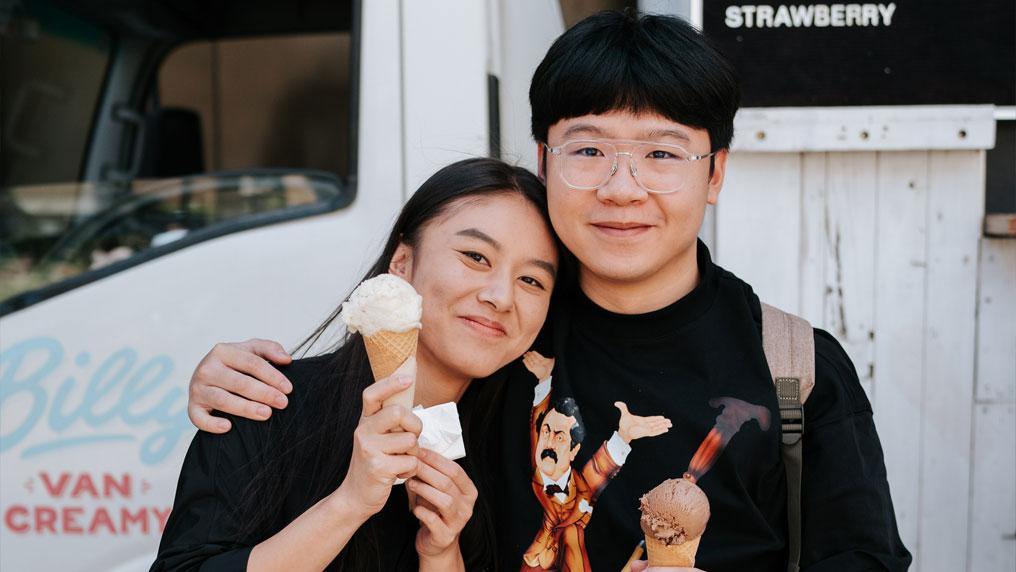 Two students standing in front of an ice cream van.
