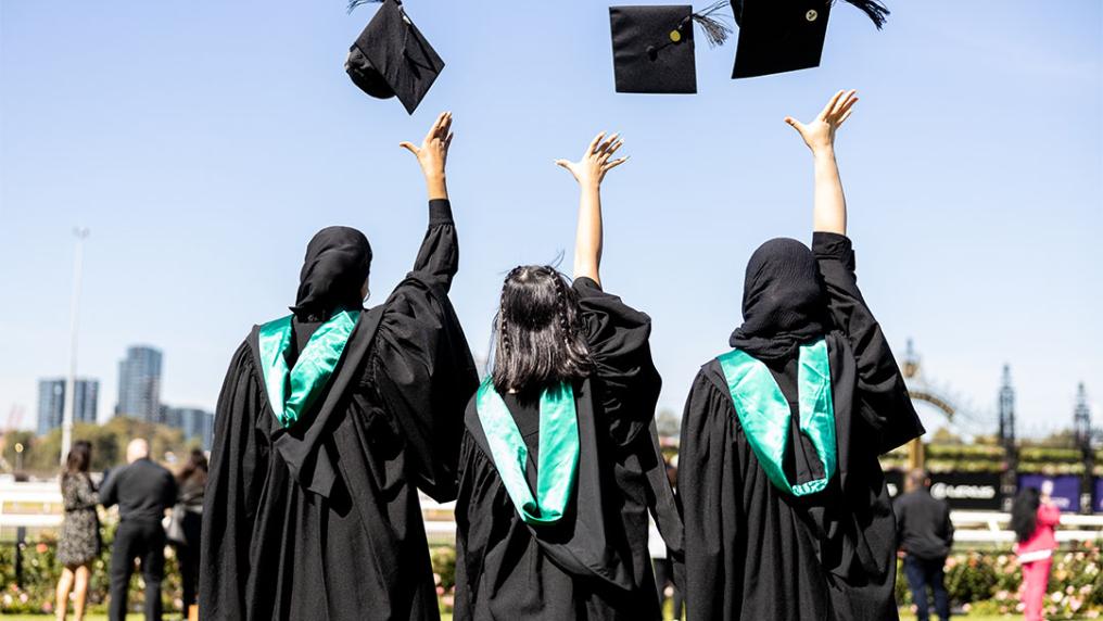 VU students throwing hats into air at graduation.