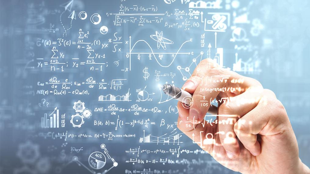 Hand writing mathematical equations on a board.