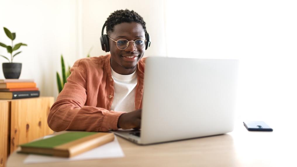Student looks happy and confident with laptop