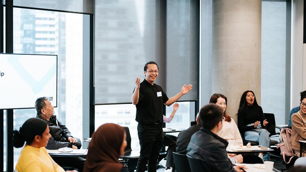 A facilitator stands in a classroom at VU's City campus, leading a workshop.