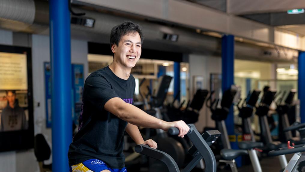 A young man using exercise equipment in well-equipped exercise room