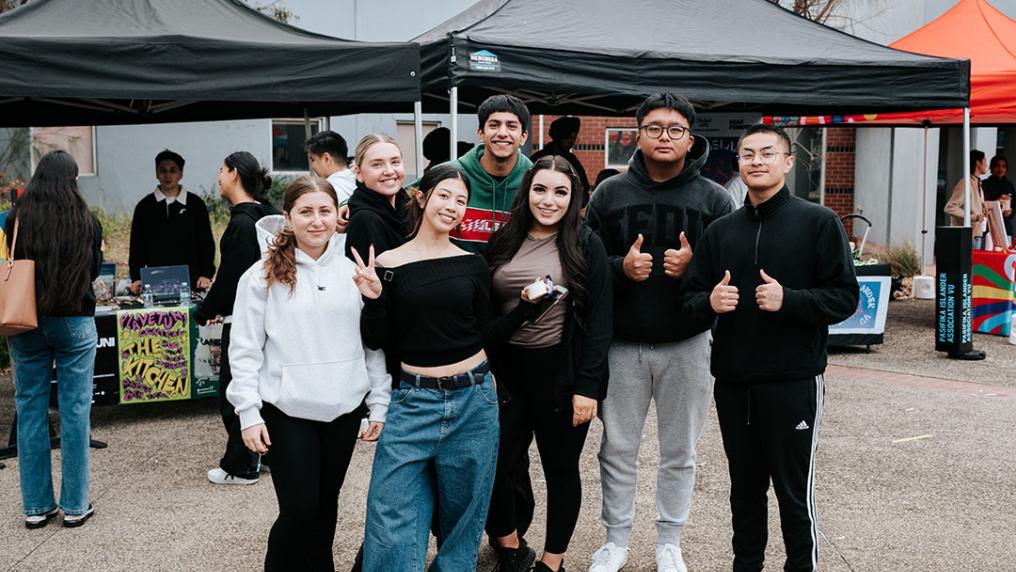 Seven students post in front of stalls at St Albans Ofest.