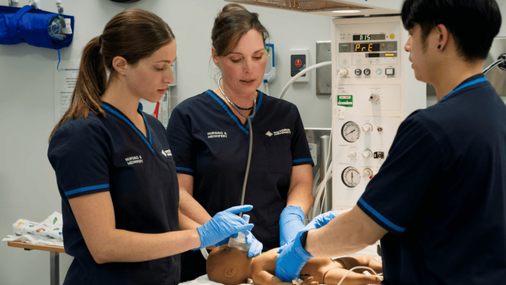 A group of midwifery students practising resuscitation on a manikin baby