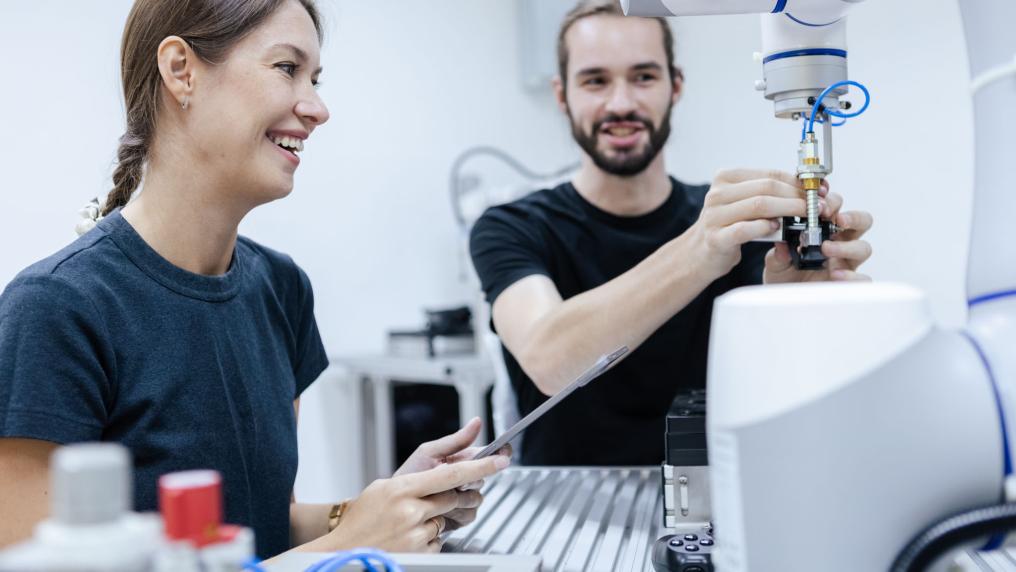 two students smiling and working in a lab together