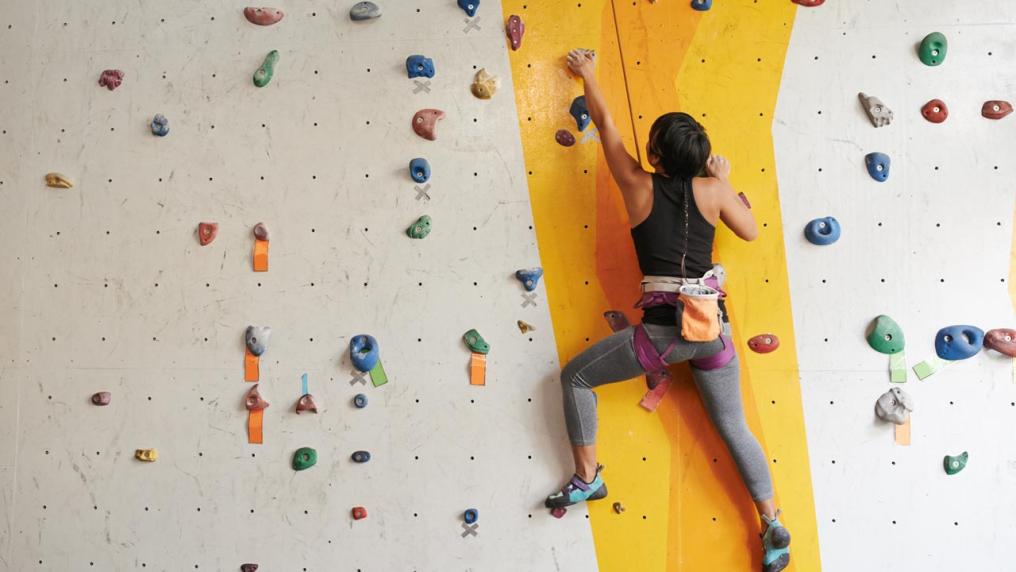 A person climbing an indoor rock climbing wall.