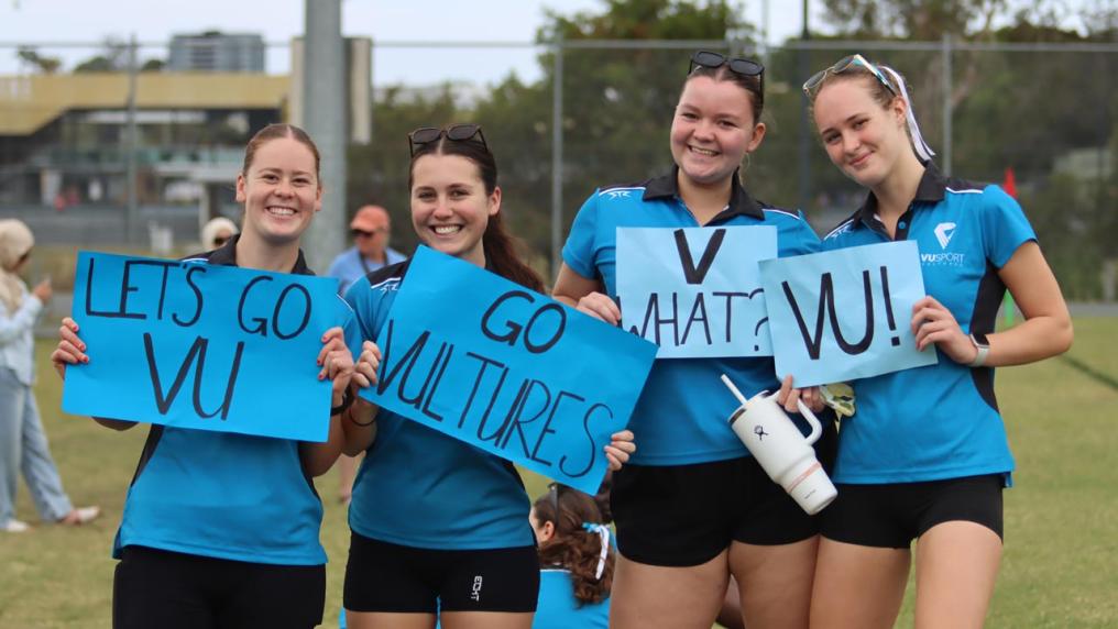 VU Vultures team members holding encouraging sport signs, like "Let's go VU!"
