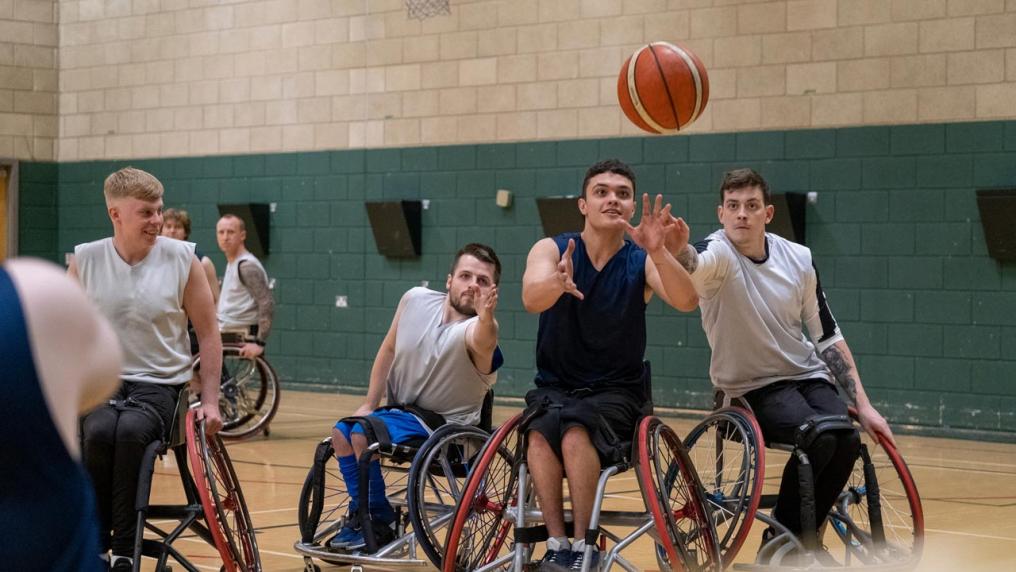 A group of people in wheelchairs playing basketball