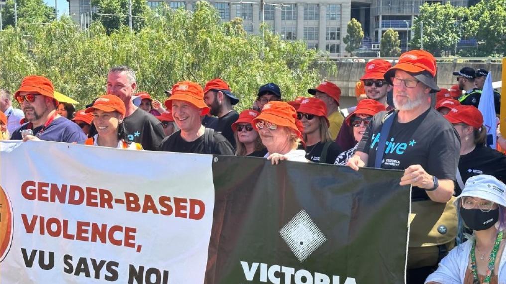 A group of staff and community members holding up a sign that reads 'Gender-based violence, VU says no!'