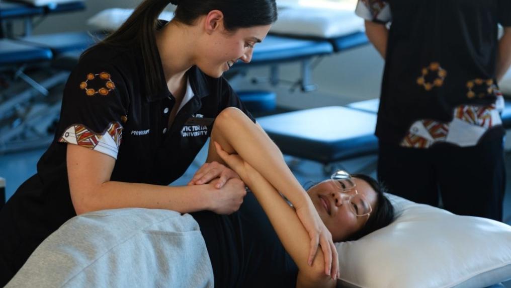 Physio student performing manual therapy in class