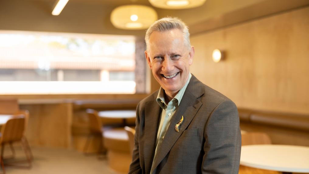Professional looking man in suit smiles at the camera.