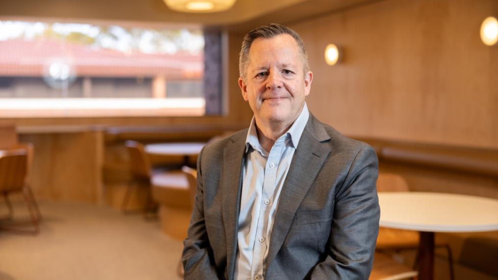 Professional looking man in suit smiles at the camera.
