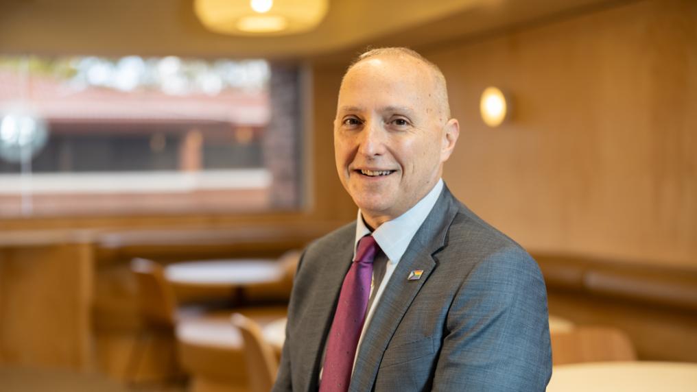 Professional looking man in suit smiles at the camera.