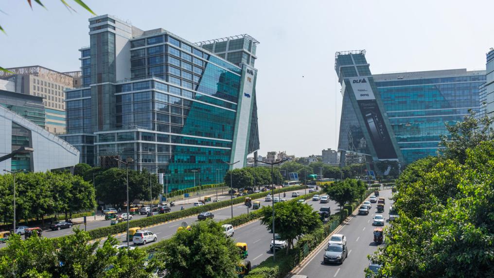 Two tall buildings surrounding a busy highway in India