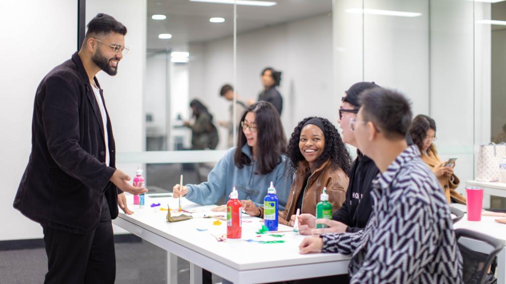 A modern white and mirrored classroom where students are engaged in discussion 