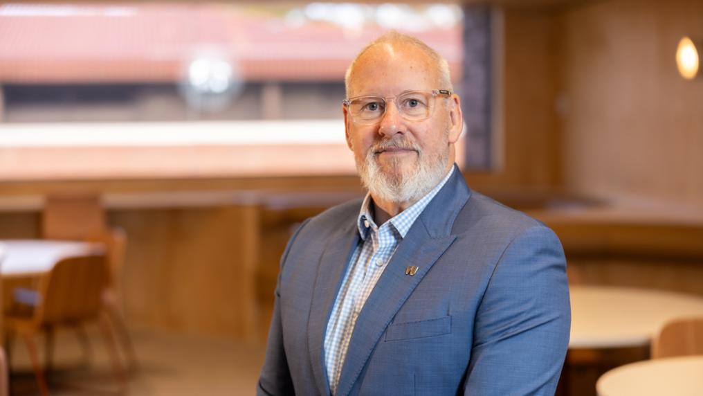 Professional looking man in suit smiles at the camera.