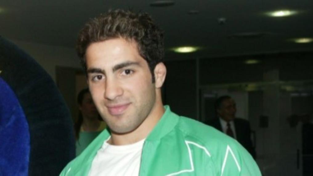 Smiling man in green sports jacket. 