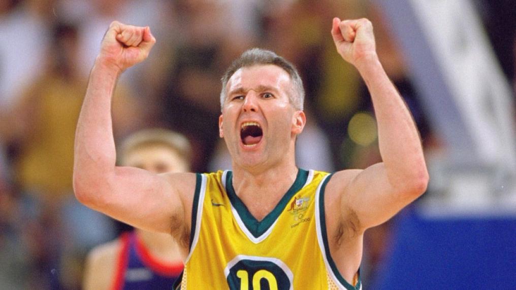 Male basketball player in yellow sports vest shouting mid-game. 