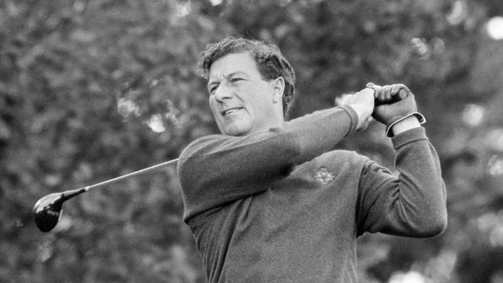 Black and white photo of male golfer swinging golf club. 