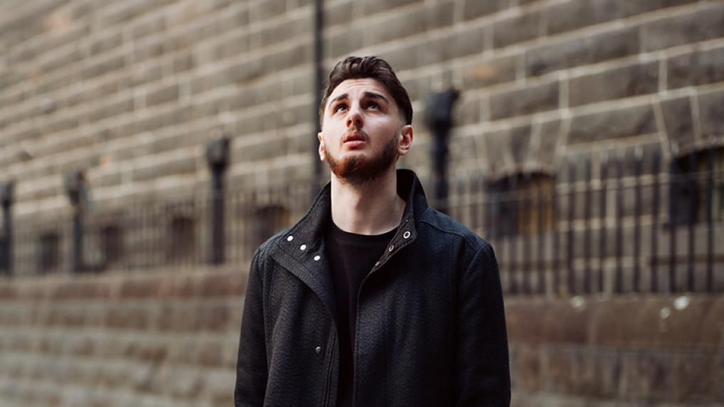 A young man looks up in awe at a colonial prison building