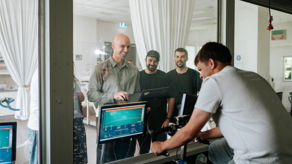 Research participant on stationary bike in environmental chamber