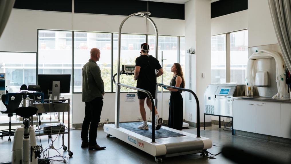 Researchers watch participant run on treadmill