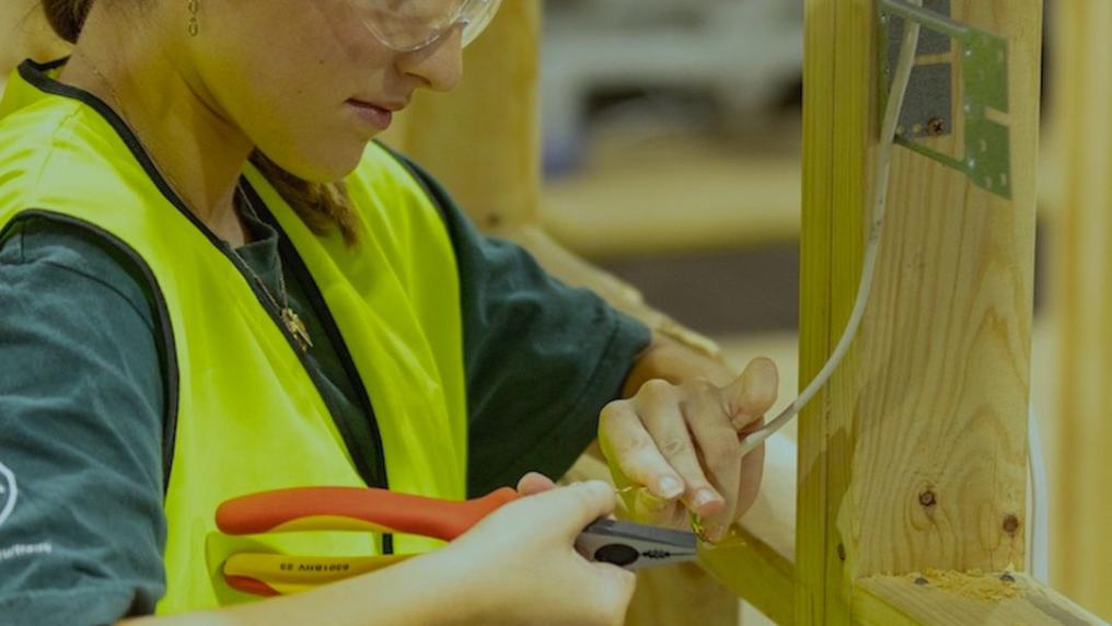 Electrotechnology student rewiring house frame