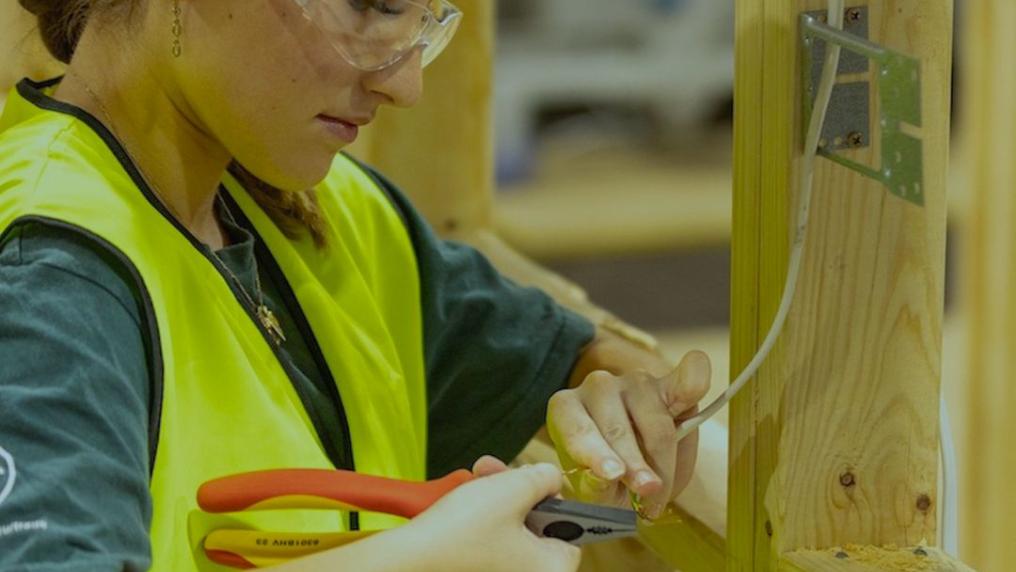 Electrotechnology student rewiring house frame