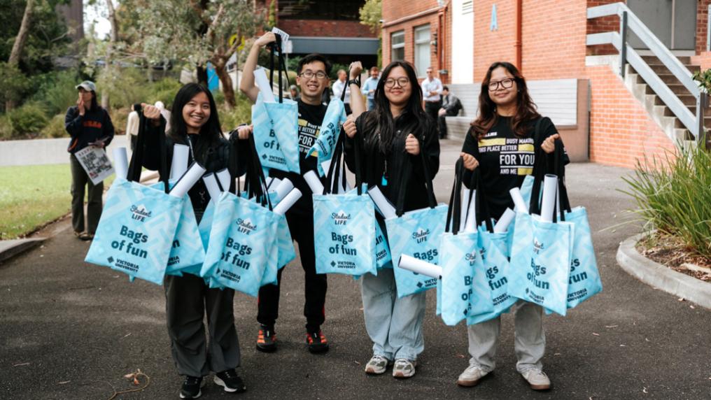 a group of students with VU blue tote bags in campus courtyard