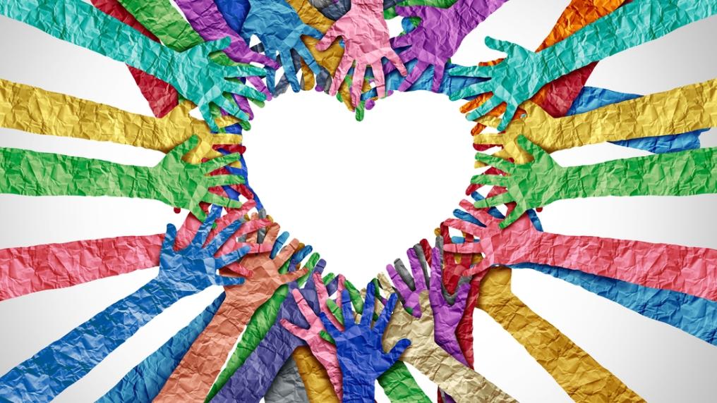 colourful paper cut out hands reaching into the centre to form a heart shape