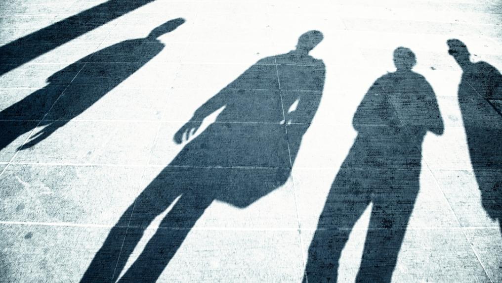 Four peoples dark shadows on the pavement
