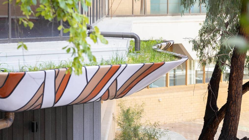 Balcony with indigenous design and colours surrounded by buildings and gumtrees