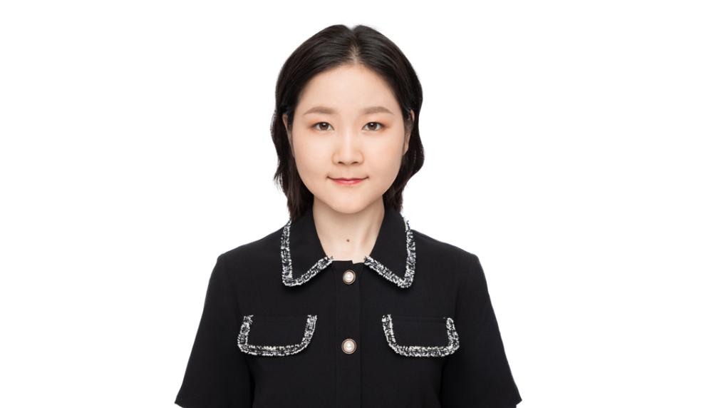 A young friendly looking woman in a neat black jacket