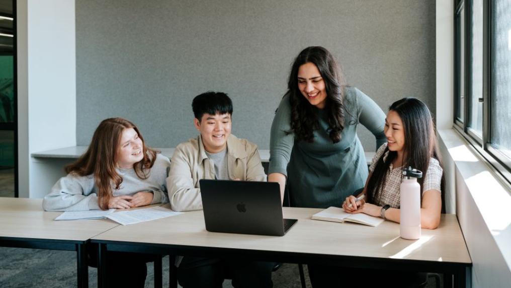 Group of students seated at a table, in discussion