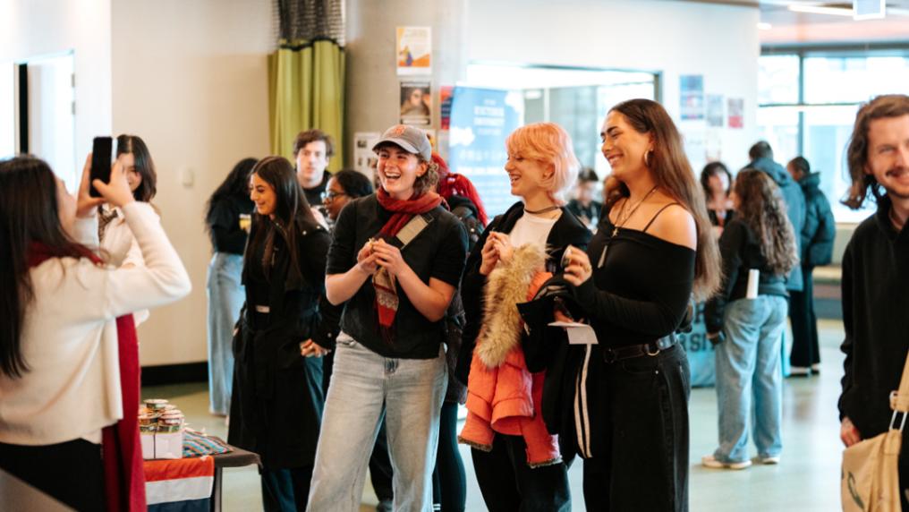 A group of happy, relaxed students at a casual event in a modern building