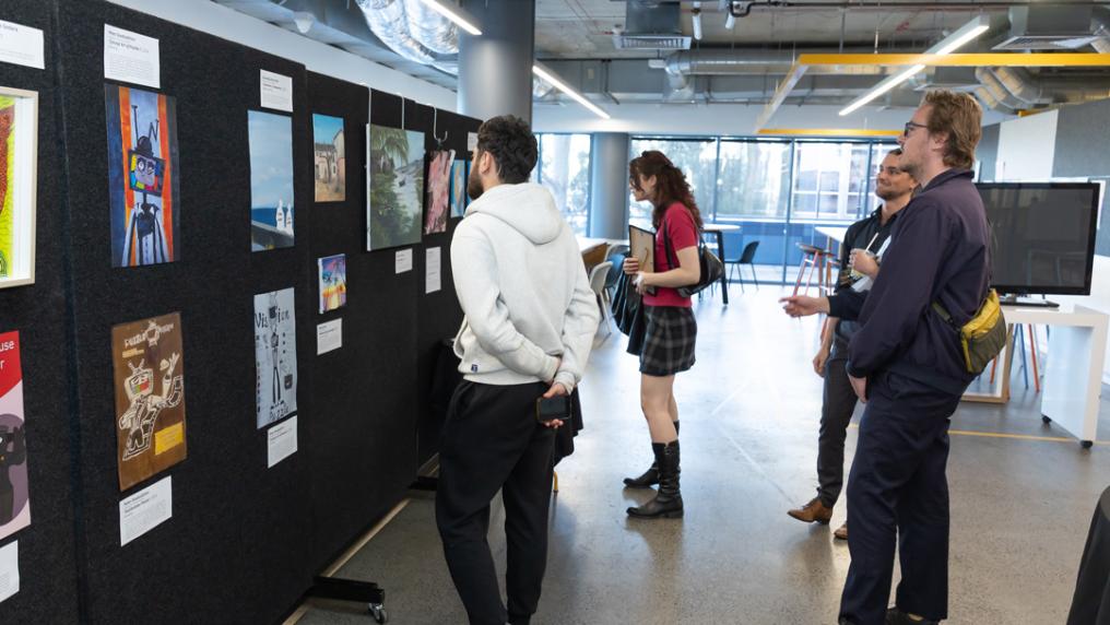 People checking out an art exhibition in a large space modern with tall windows