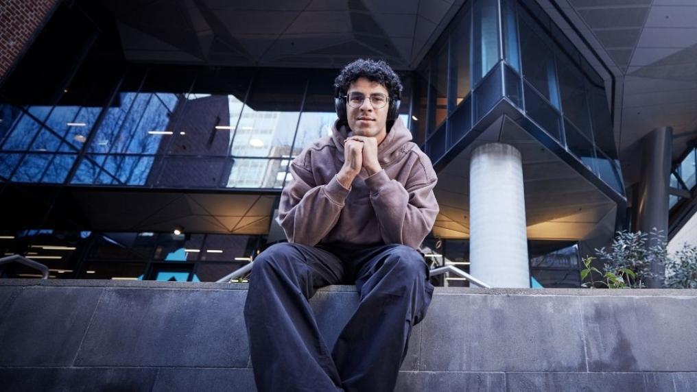 Student sitting outside VU City Tower