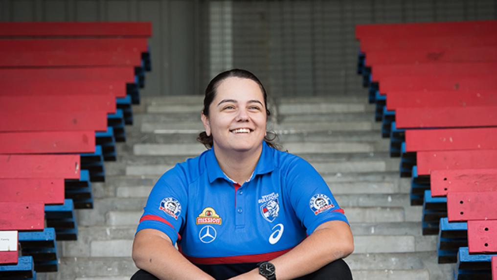 Brooke Muscat in Western Bulldogs uniform sitting on steps in a stadium