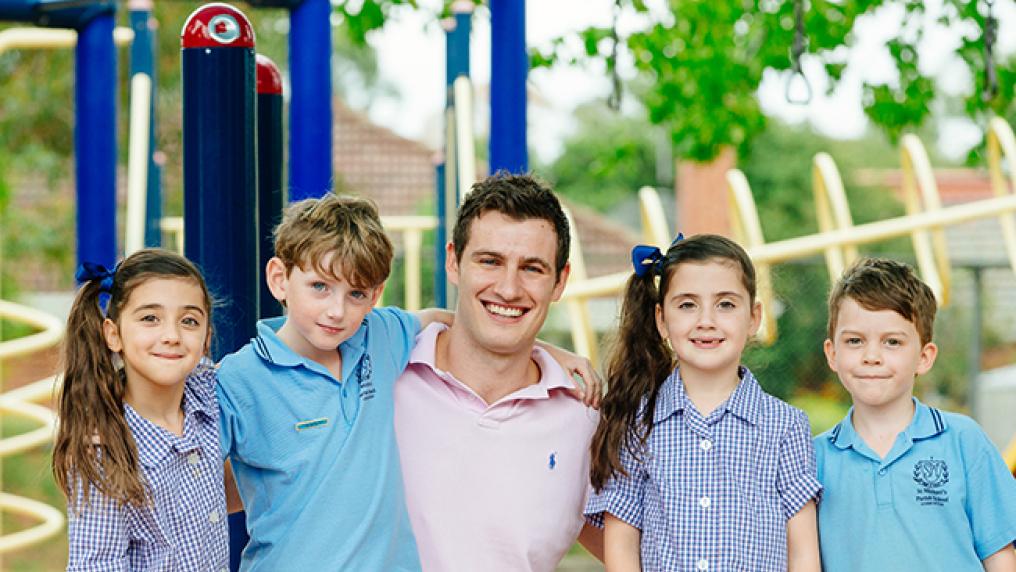 Christian Williams with four school children in a playground