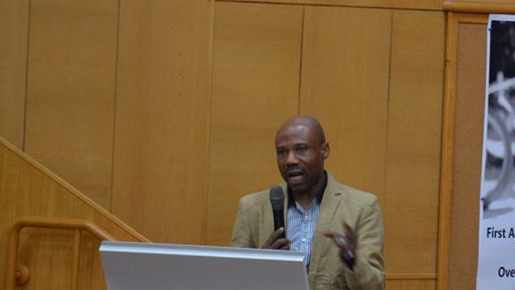 Christo Odeyemi presenting at a lectern