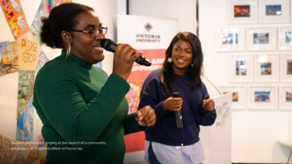 Two African-Australian young women on the mic at a public event